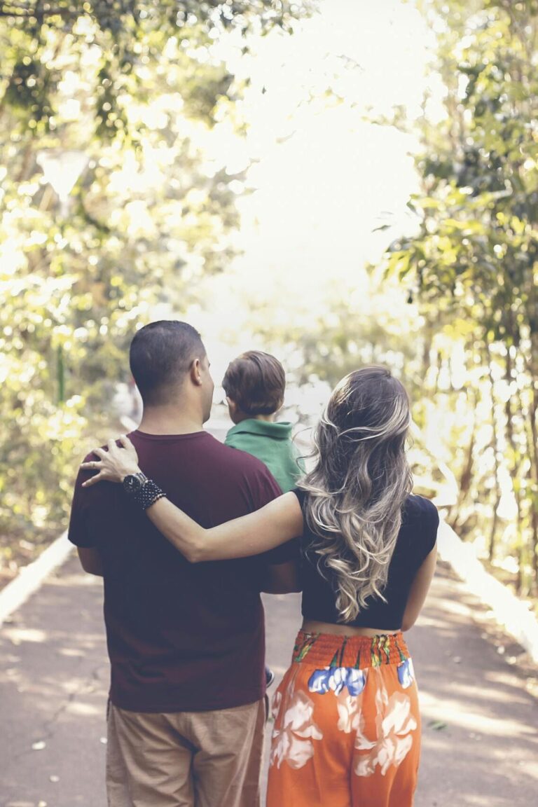 A family enjoying a leisurely walk on a sunny park trail, showcasing togetherness and love.