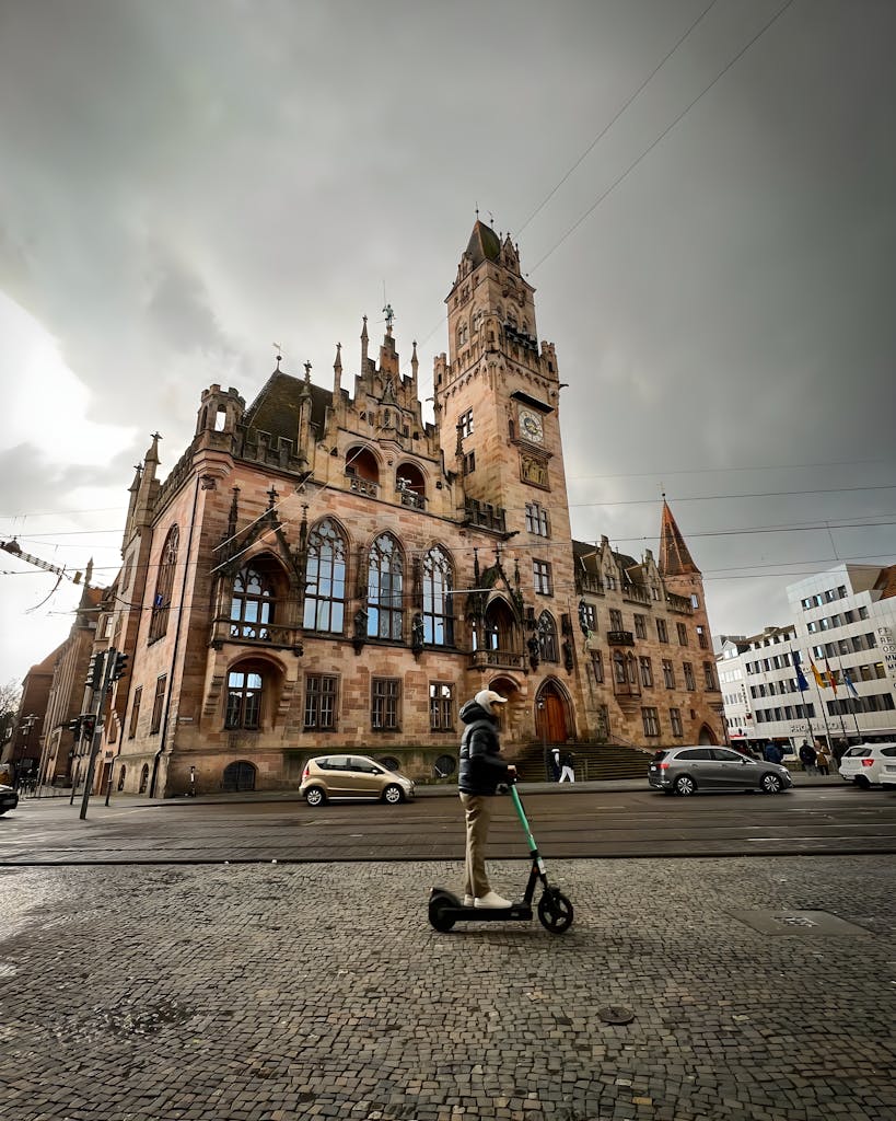 View of the Saarbrücken Town Hall with a person on a scooter in the foreground.